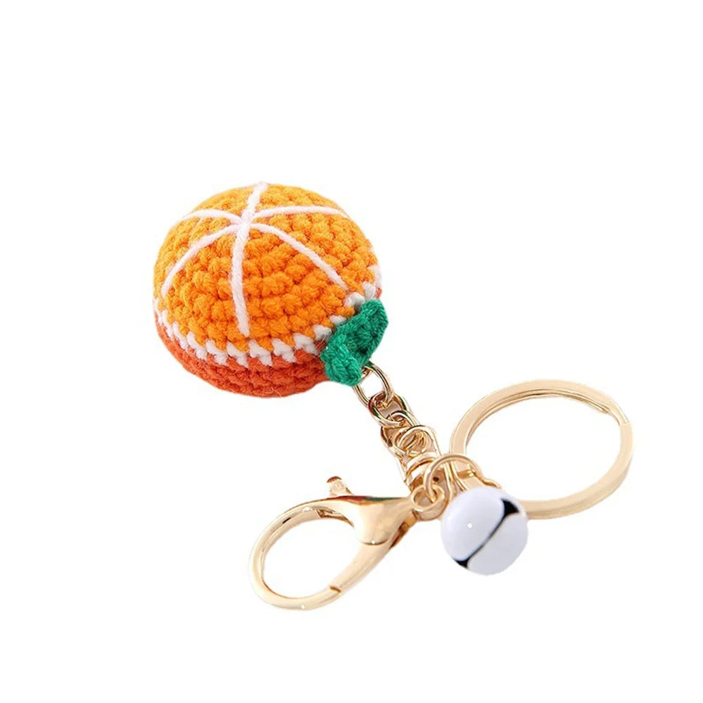 Handmade crochet orange fruit keychain pendant with a gold-toned ring and white bead.