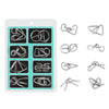 A white tray holds various metal wire puzzle pieces for a brain teaser or IQ challenge.