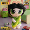 A collectible figure of Blossom from The Powerpuff Girls, featuring black hair and green eyes, displayed on a purple surface.