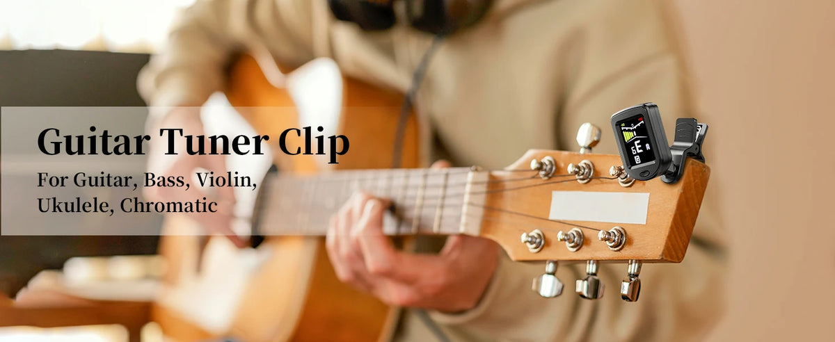 A hand is using a clip-on tuner on a wooden stringed instrument, likely a guitar or bass.