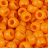 A close-up view of small, solid orange pony beads for jewelry making and craft projects.