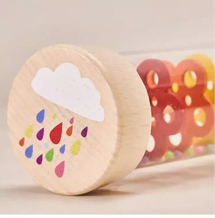 A wooden rain sound shaker toy with colorful drops and clouds, used for early learning.