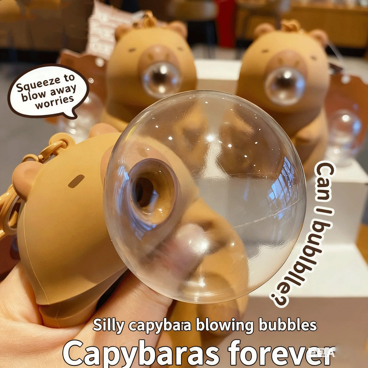 A hand holds a tan capybara squeeze toy blowing bubbles against a white background.