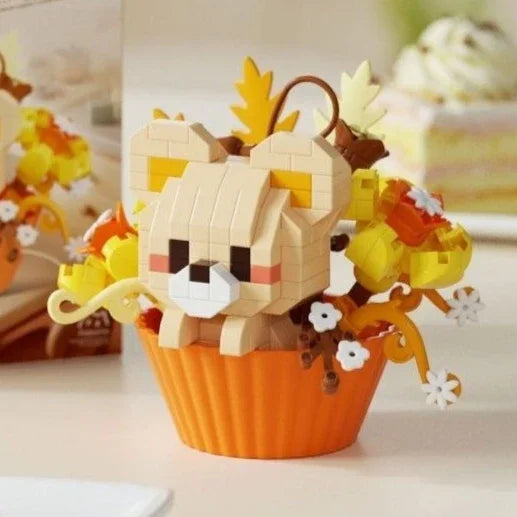 A wooden building block set shaped like a bear holding a colorful floral bouquet in an orange cupcake liner.