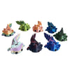 A set of eight colorful flexible salamander figurines in shades of green, orange, and blue.