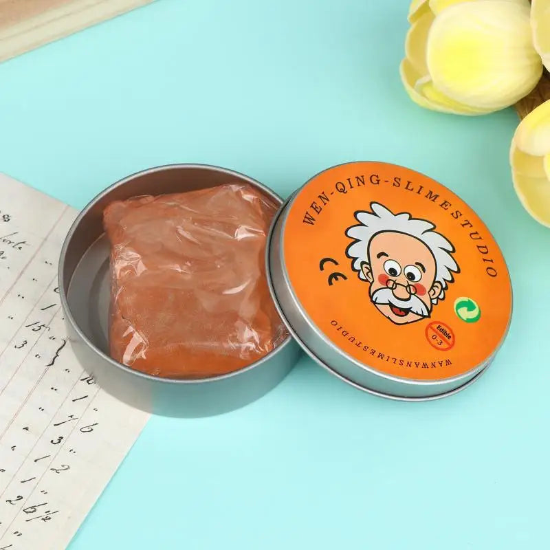 A jar of orange liquid glass crystal slime next to a ruler on a light blue background.