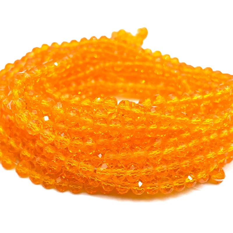 A coil of bright orange faceted crystal beads used for jewelry making.