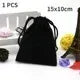 A black fabric pouch is shown next to a set of RPG dice and a white box.