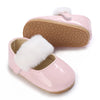 Pink lace-trimmed moccasin shoes for a baby girl with white faux fur trim