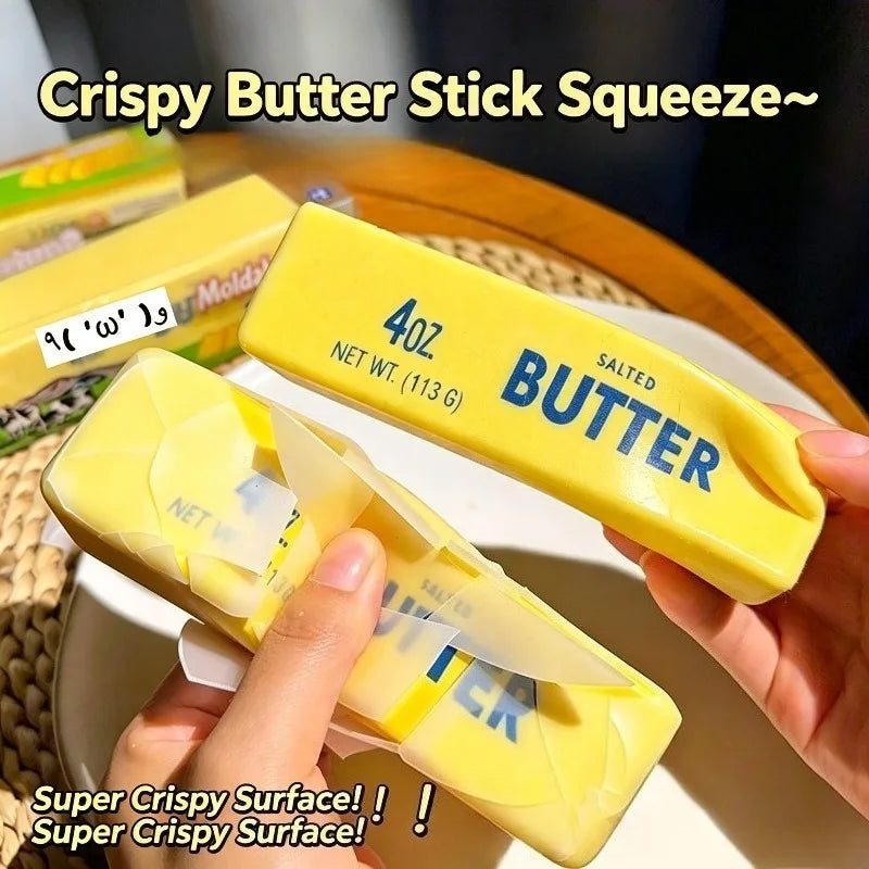 A hand holds a yellow butter stick squeeze toy with salted butter inside, demonstrating its crispy surface.