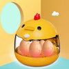 A yellow compact automatic egg incubator with a transparent window showing several brown eggs inside.