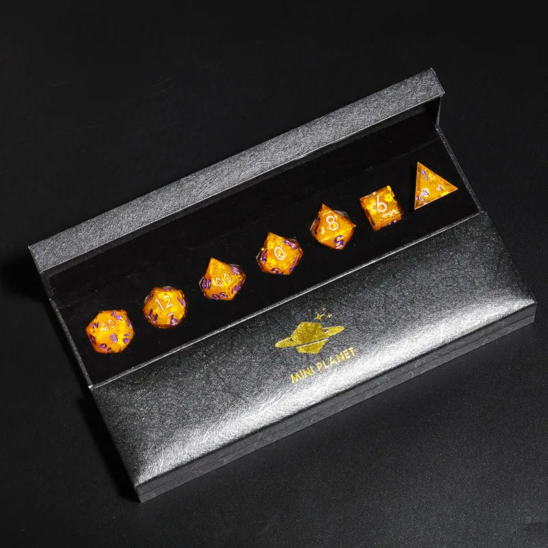 A set of six yellow and orange resin polyhedral dice displayed inside a dark gray box labeled Mini Planet.