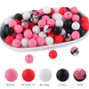 A variety of soft food-grade silicone beads in pink, red, white, and black are displayed in a white oval dish.