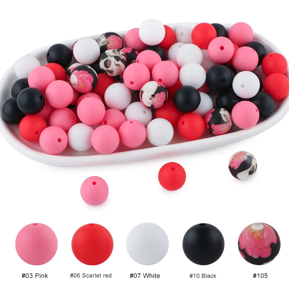 A variety of soft food-grade silicone beads in pink, red, white, and black are displayed in a white oval dish.