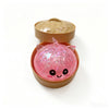 A pink unicorn squishy stress ball is shown in an open bamboo steamer box.
