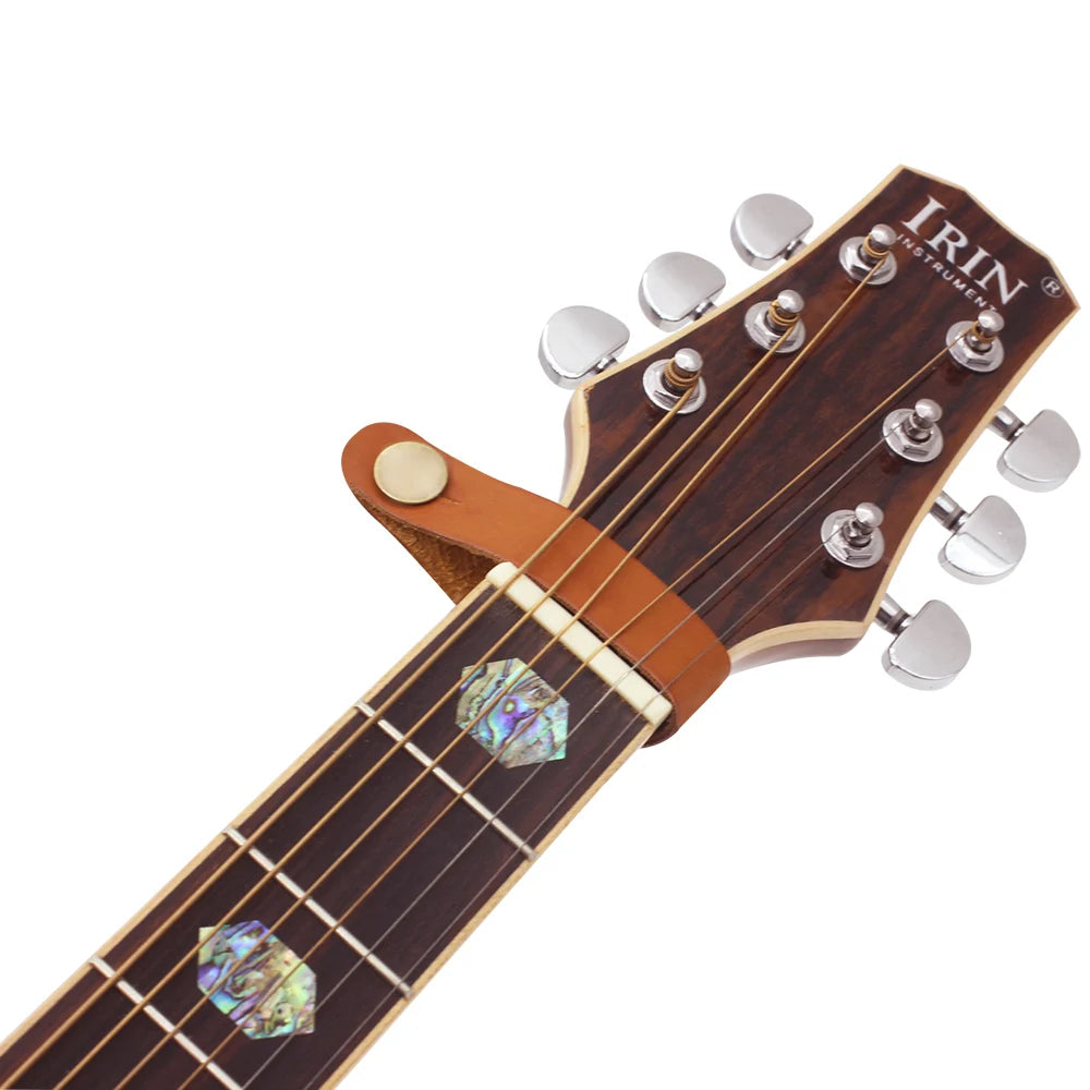 A close-up view of a brown leather guitar strap button with a silver metal fastener.
