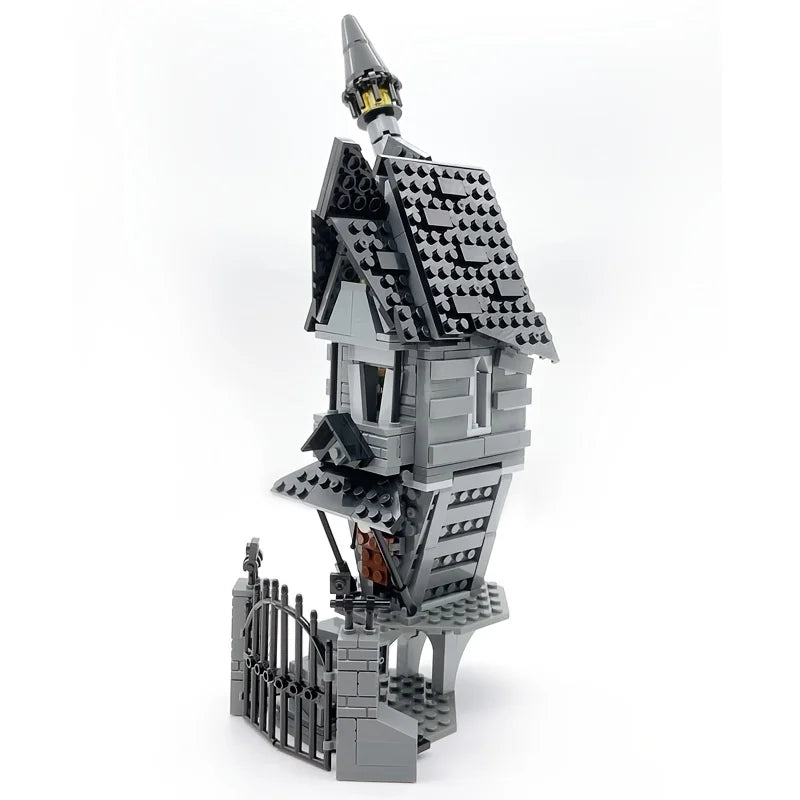 A gray LEGO building block set depicting a haunted house with a turret and surrounding fence.