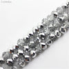 A close-up of silver and clear crystal glass beads used as round spacers for jewelry making.