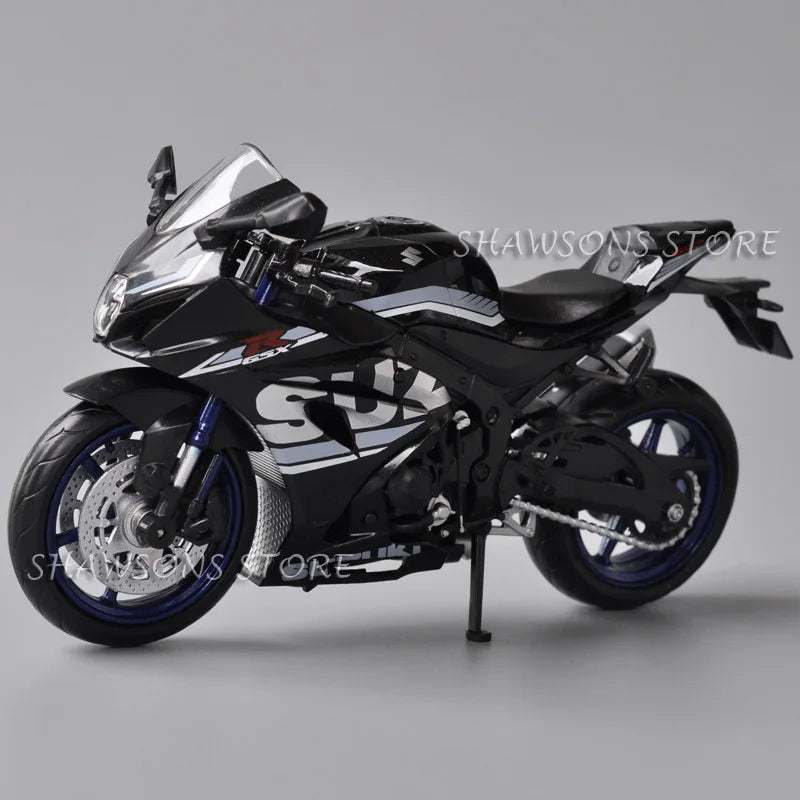 A black Suzuki GSX-R1000R diecast motorcycle model in a studio setting.