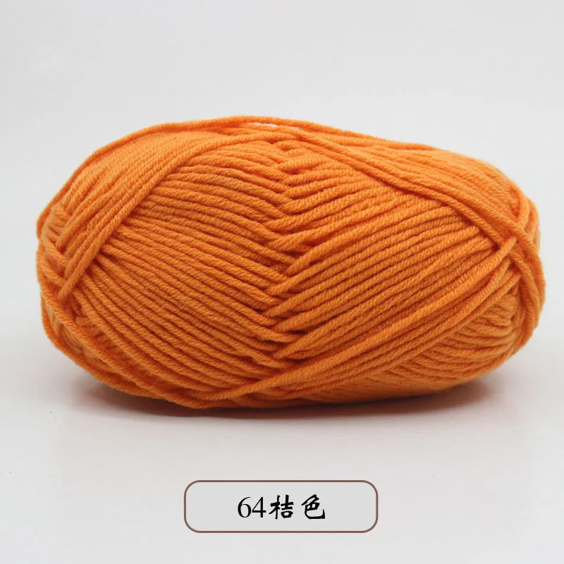 A ball of bright orange pre-dyed milk cotton yarn used for knitting and crochet.