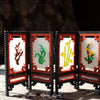 A display of fuse beads in assorted colors arranged in a decorative wooden frame.