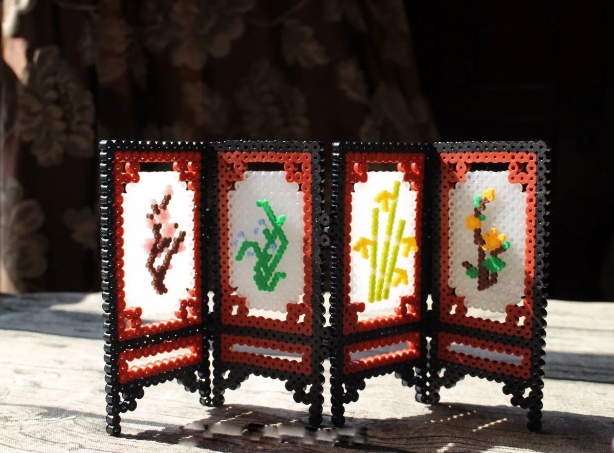 A display of fuse beads in assorted colors arranged in a decorative wooden frame.
