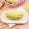 A yellow squishy stress ball shaped like a peanut is displayed on a white plate with pink and yellow checkered fabric.