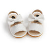 Pair of white baby summer sandals with a bowknot design and soft anti-slip sole.