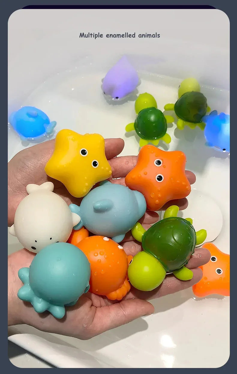A hand holds multiple glow-in-the-dark animal washing water toys in various colors like yellow, orange, green, and blue.