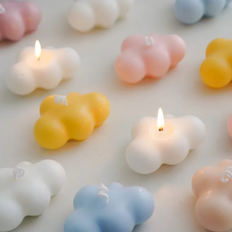Various cloud-shaped silicone molds in pastel colors including pink yellow and blue for crafting