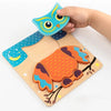 A hand is holding a wooden puzzle featuring an owl and a traffic light design for children's learning.