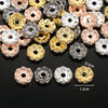 A collection of 12mm crystal rhinestone spacer beads in various gold and silver tones are displayed on a dark surface.