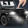 A hand points at a black diecast metal RV camper truck model with lights and sound.