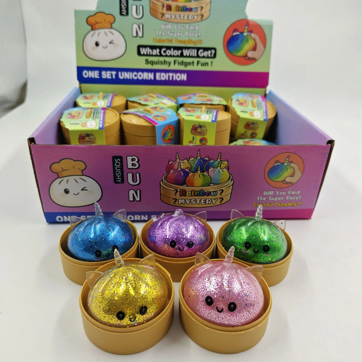 A set of glitter unicorn dumpling squishy fidget toys in various colors packaged in a box.
