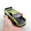 A hand holds a lime green die-cast sports car with pull-back action.