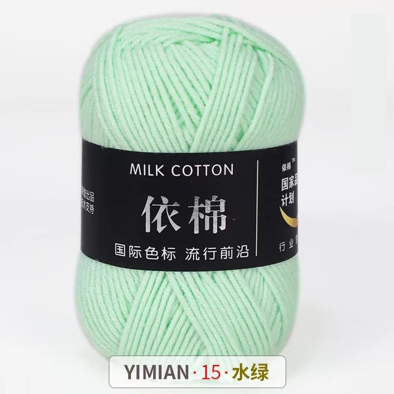 A ball of light green milk cotton yarn labeled YIMIAN 15, ready for knitting or crochet.