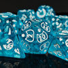 A close-up of bright blue polyhedral dice scattered on a dark surface.