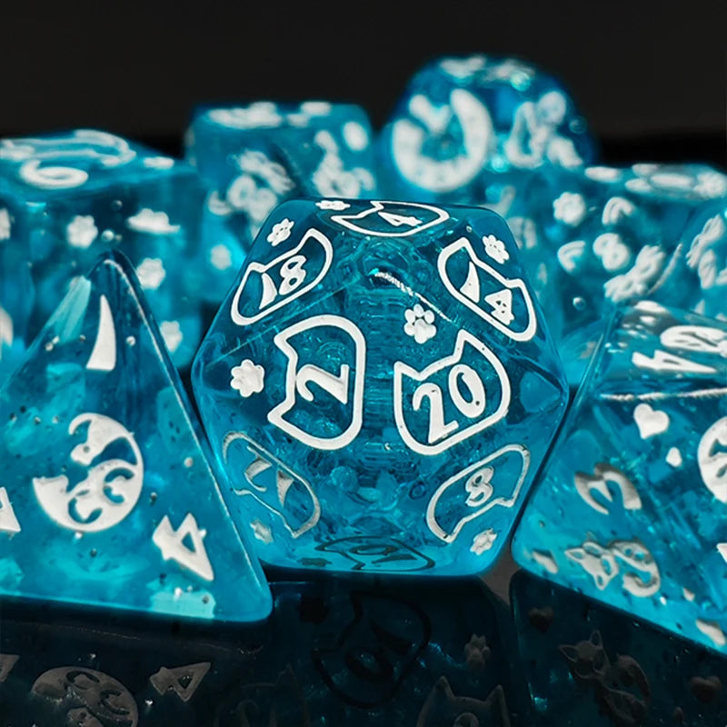 A close-up of bright blue polyhedral dice scattered on a dark surface.