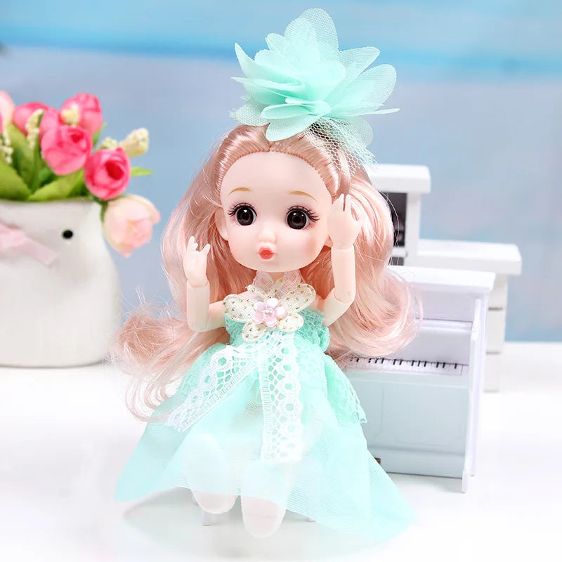 A pink-haired doll with a light blue dress and a mint green bow is shown next to a typewriter.
