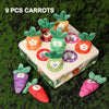 Nine colorful carrot pull toys for toddlers arranged on a green surface.