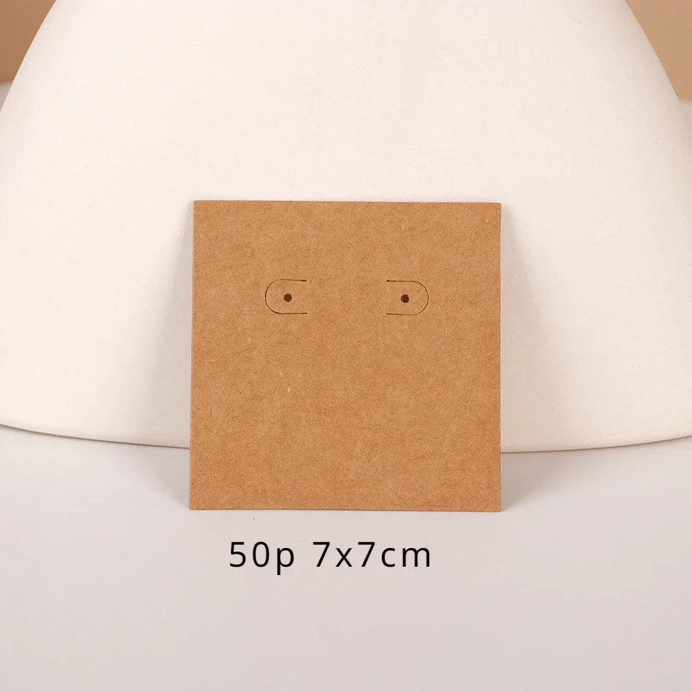 A square brown kraft card with two small cutouts is displayed on a white surface.