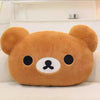 A soft, brown Rilakkuma plush hand rest pillow with black eyes and a small nose.