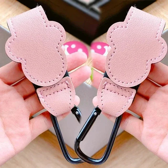 Pink PU leather stroller organizer hooks with a cute cloud design being held by a hand