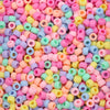 A close-up view of a large pile of solid color pony beads in various shades of pink, yellow, blue, and green.