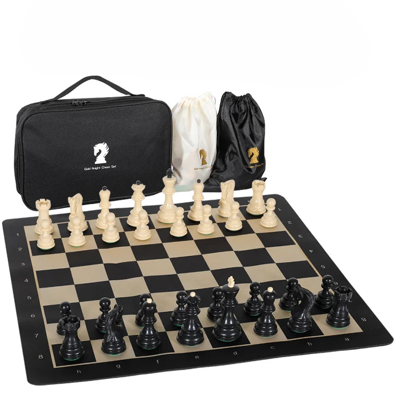 A portable folding chess set with weighted pieces displayed on a black board next to a black carrying bag and a white cloth b