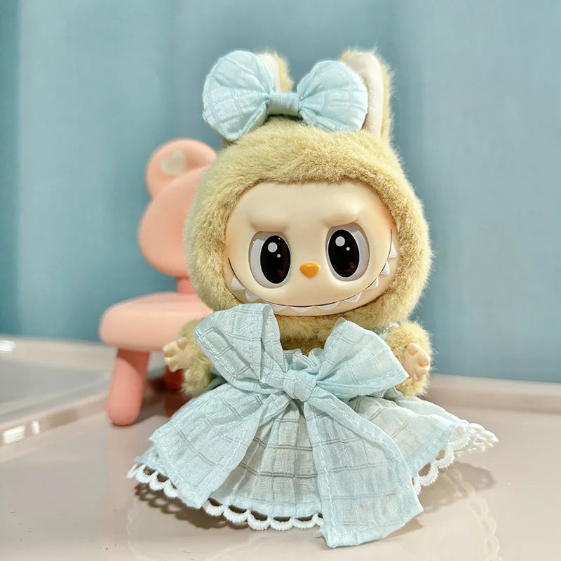 A cute, light yellow doll wearing a light blue bow and a matching dress with lace trim.