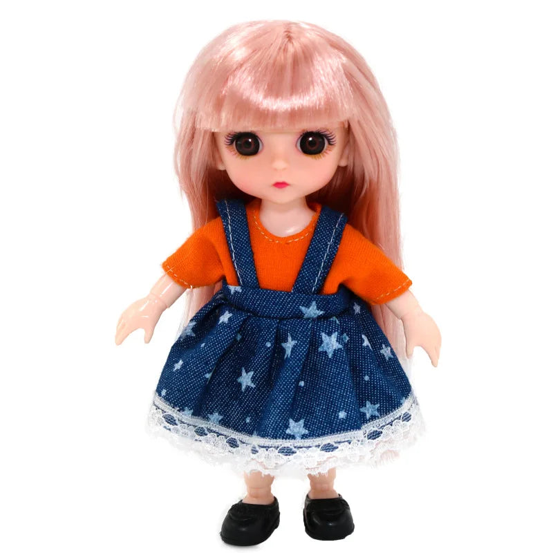 A pink-haired BJD princess doll wearing an orange top and a blue patterned dress.