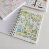 A close-up of a spiral-bound sticker book filled with cute, colorful illustrations and stickers for journaling.