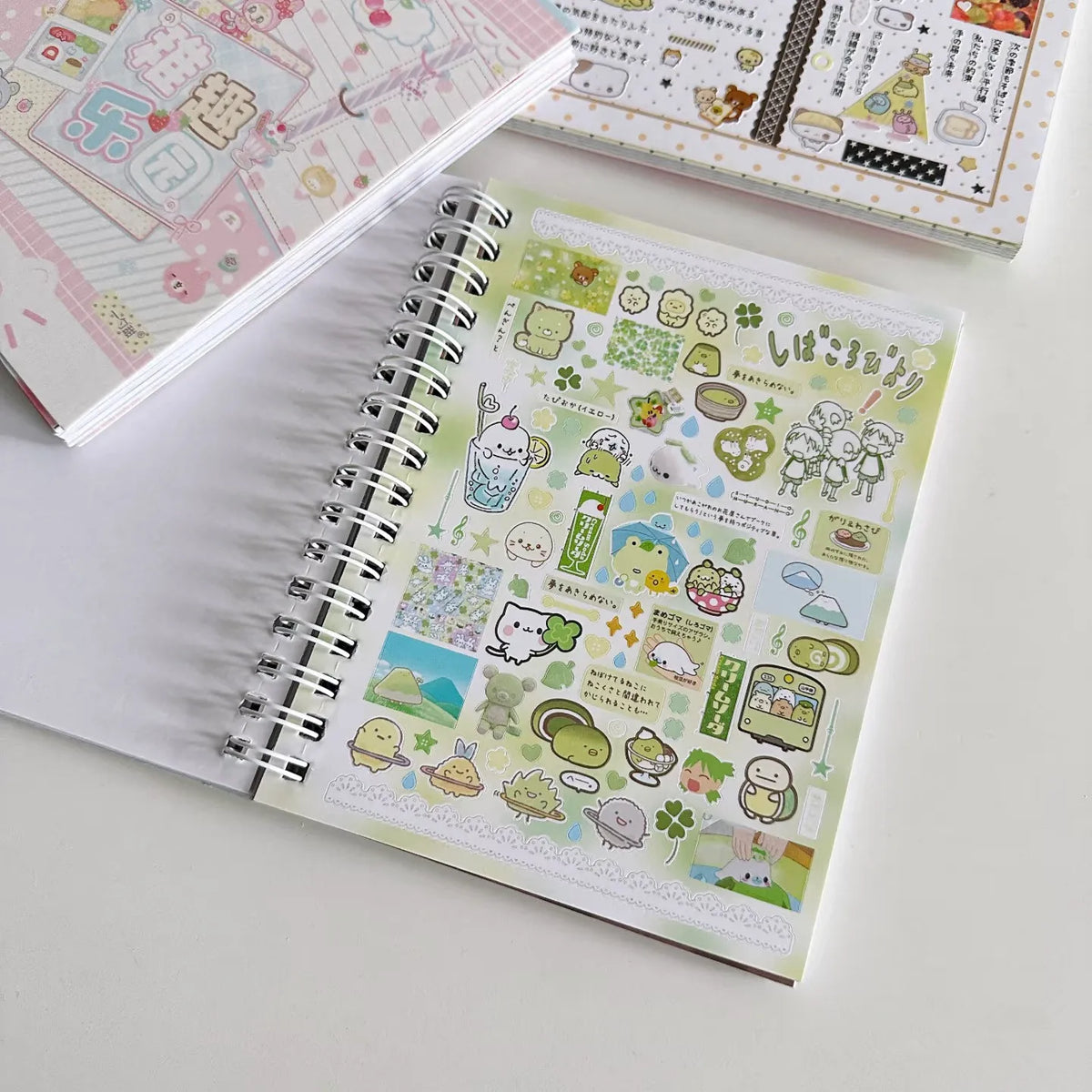 A close-up of a pastel green and white sticker book with various cute illustrations for journaling and scrapbooking.