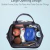 A dark gray waterproof diaper backpack with an interior changing mat, various accessories, and a smartphone visible.